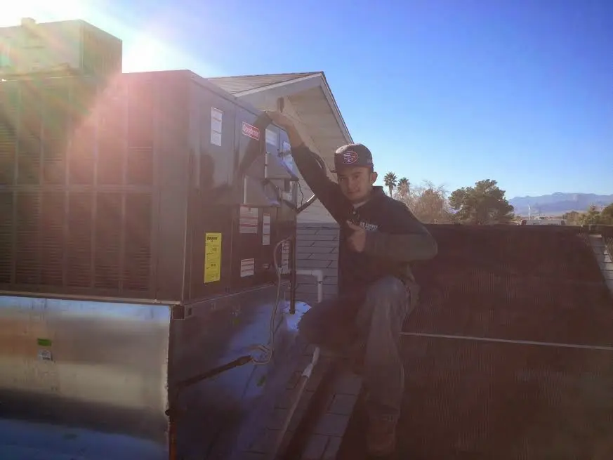 HVAC technician performing HVAC Inspection on a rooftop unit in Carmel